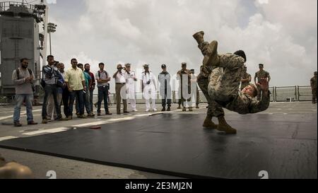 I marines assegnati alla quindicesima unità di spedizione marina (quindicesimo MEU) mostrano tecniche di decollo ai media locali durante un programma di arti marziali del corpo dei Marine a bordo della nave di atterraggio del molo anfibio USS Pearl Harbor (LSD 52). Foto Stock