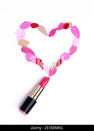 San Valentino sfondo. Rossetto rosso e rosa a forma di cuore. Isolato su sfondo bianco. Prodotti cosmetici Foto Stock