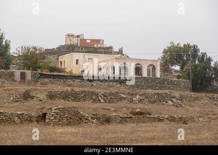 Ano Meira, Isola di Folegandros, Grecia - 24 settembre 2020: Gli edifici di una piccola città sull'isola con le rovine di un mulino a vento nel centro. Foto Stock