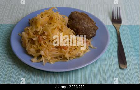 Cavolo bianco stufato con una bistecca di cotoletta su un piatto. Un piatto di cucina russa. Guarnire nell'URSS. Foto Stock