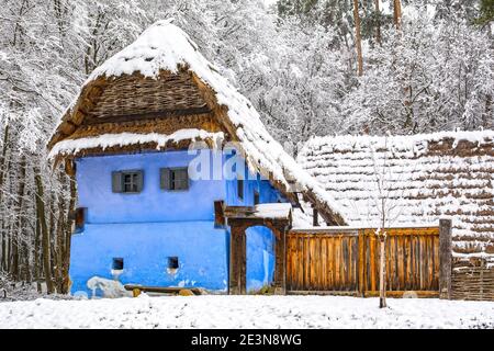 Bella vecchia casa blu tradizionale in Astra museo all'aperto a Sibiu, Transilvania, durante la stagione invernale con la neve Foto Stock