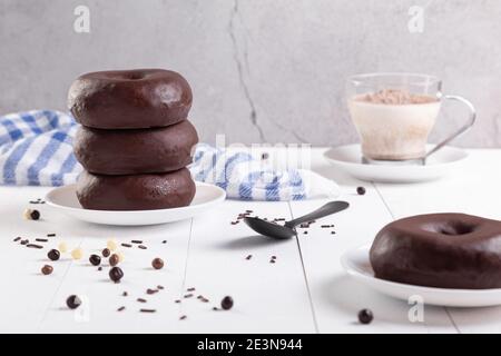 Pila di ciambelle di cioccolato su sfondo chiaro. Foto Stock