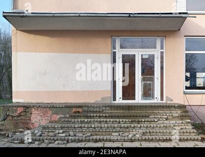 Vecchie finestre e porte in vetro di plastica e scala in pietra distrutta Foto Stock