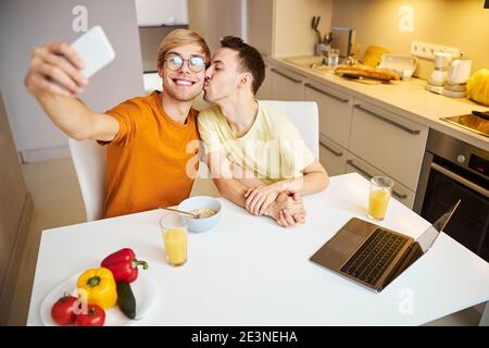 Felice coppia gay che fa selfie a casa Foto Stock
