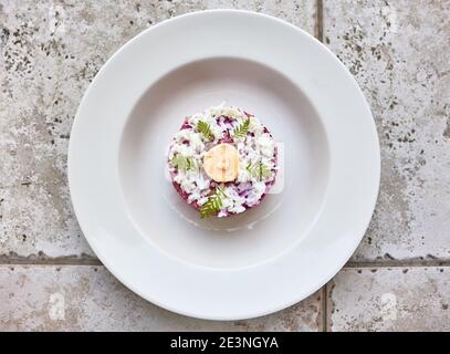 porzione di aringa e insalata di barbabietola su piatto bianco, vista dall'alto Foto Stock