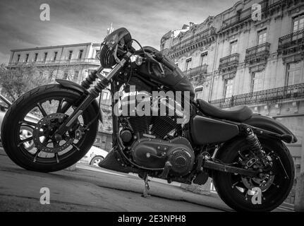 Harley Davidson moto in una strada in una città francese con vecchi edifici storici sullo sfondo - nero e. bianco Foto Stock