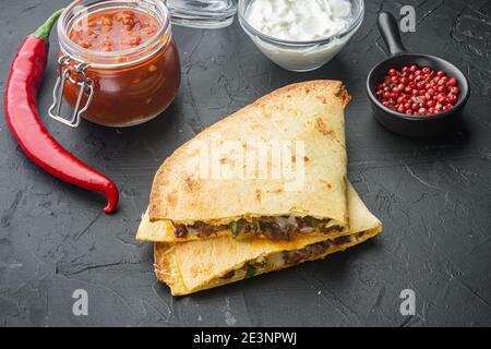 Involtino di quesadilla messicana con pollo, mais e pepe dolce e salsa di salsa, su fondo nero Foto Stock