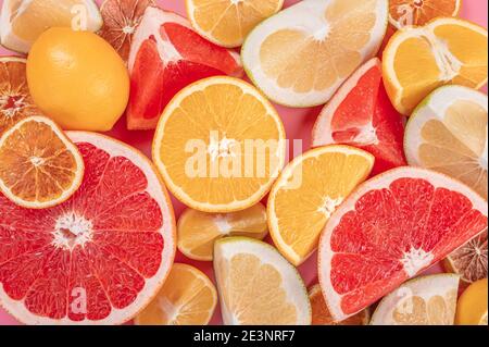 Mucchio di agrumi freschi. Vista dall'alto di agrumi, arancia, mandarino, limone, lime e pompelmo o cerchi su sfondo rosa. Vista dall'alto Foto Stock