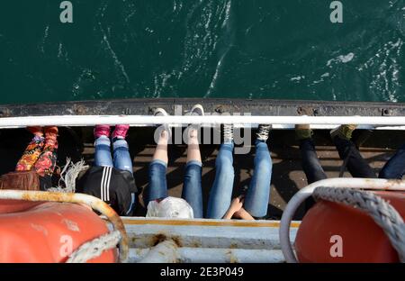Persone che si mettono i piedi su un traghetto di Istanbul attraverso gli stretti del Bosforo. Breve traversata di 20 minuti, quindi avrai la possibilità di rilassarti e guardare il mondo. Foto Stock