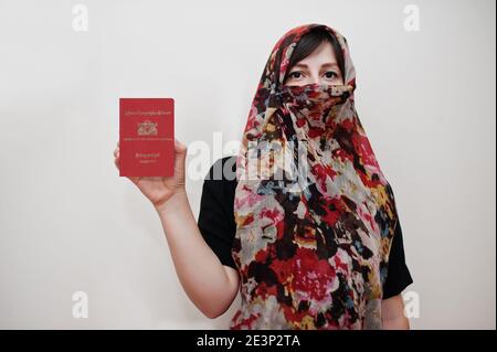 Giovane musulmana araba in abiti hijab tenere Repubblica dell'Unione di Myanmar passaporto su sfondo bianco parete, studio ritratto. Foto Stock