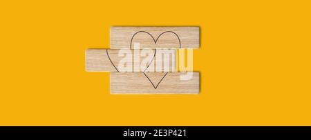 Immagine concettuale di un'idea d'amore di successo. Segno di cuore in blocchi di legno su sfondo giallo - completamento del processo e realizzazione in Creative idea wi Foto Stock