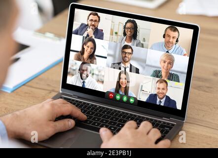Uomo d'affari che fa la videochiamata via il laptop che ha riunione in linea, ritagliato Foto Stock