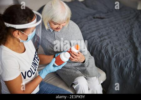 Allegra vecchia donna e volontaria affettuosa delle pillole Foto Stock