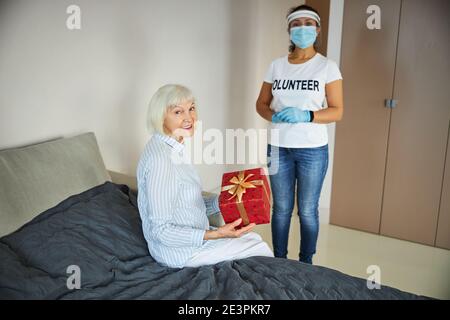 Donna che invecchia felice sta tenendo un regalo Foto Stock