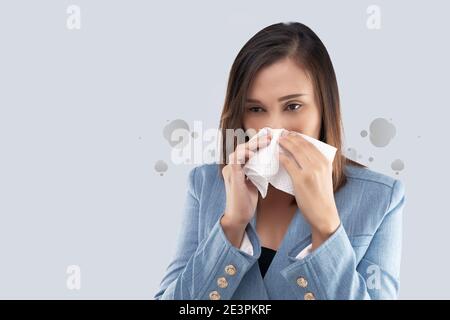 Sensazione di bruciore al naso di una donna d'affari a causa del fumo tossico e del particolato presente nell'aria. Donna con allergia, tenendo un tessuto sul naso. P. Foto Stock