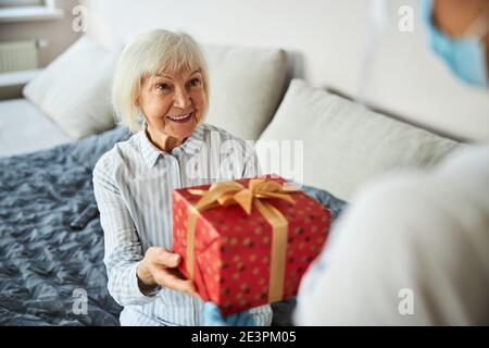 Donna in pensione che prende un imballaggio di festa Foto Stock