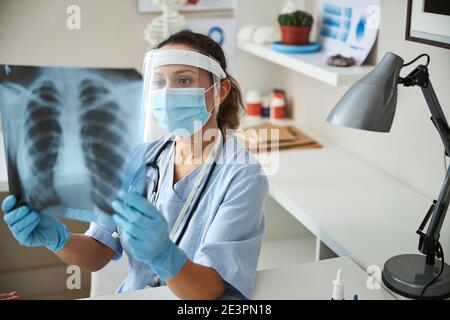 Medico che cerca le anomalie in un radiografia Foto Stock