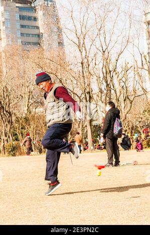 Un uomo si esercita usando uno yo-yo cinese nel Fuxing Park di Shanghai. Foto Stock