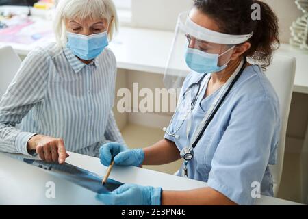 Medico che indica un problema toracico su una radiografia Foto Stock