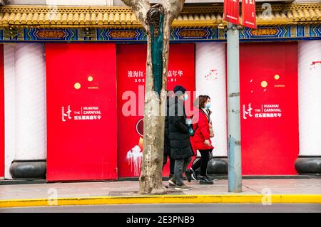 Gli amanti dello shopping passano accanto a un cartello per il Carnevale di Huaihai sulla centrale Huai Hai Road, una delle principali vie dello shopping di Shanghai. Foto Stock