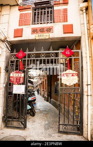 Porta d'ingresso ad un vicolo di tradizionali case shikumen al di fuori della centrale Huai Hai Road, una delle principali strade dello shopping di Shanghai. Foto Stock