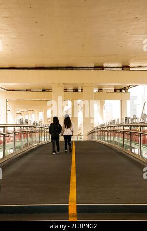 Le persone che attraversano il ponte pedonale sulla Chongqing South Road intorno al centro di Huai Hai Road, una delle principali vie dello shopping a Shanghai. Foto Stock