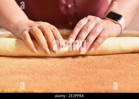 Casalinga produce dolci alla cannella, facendo pasticceria fatta in casa Foto Stock