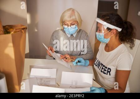 Due donne che cercano di dare un senso alla bolletta dell'utilità Foto Stock