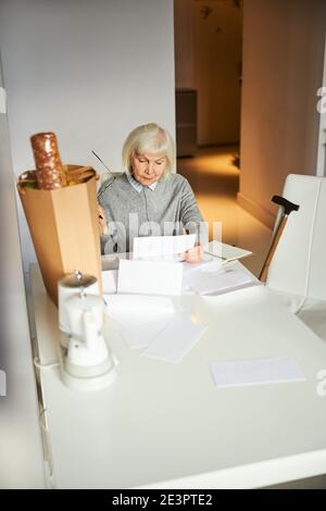 Pensionato concentrato fissando un foglio di carta Foto Stock