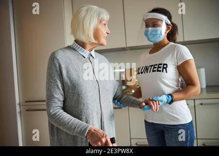Pensionato soddisfatto con un cane che guarda un caregiver Foto Stock