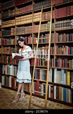 FRANCIA / IIe-de-France / Parigi / bella donna che legge un libro in libreria antica a Parigi. Foto Stock