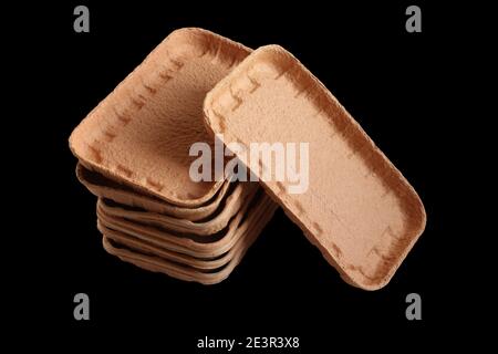 Vassoi per alimenti biodegradabili realizzati in cartone pressato isolato su sfondo nero. Primo piano Foto Stock