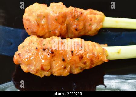 pollo arrosto fermentando polvere curcuma stabbing in erba di limone su piastra Foto Stock