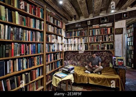 FRANCIA / IIe-de-France / Parigi /Man leggere il libro a Shakespeare and Company a Parigi . Foto Stock