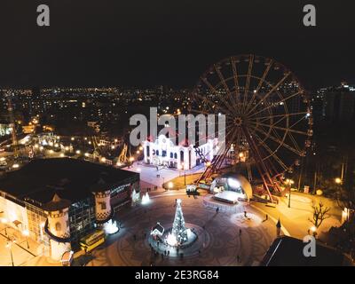 Ruota panoramica nel parco di Maxim Gorky non funziona nelle vacanze invernali, luci di illuminazione nel parco del centro di Kharkiv. Vista aerea ravvicinata di notte sulla città Foto Stock