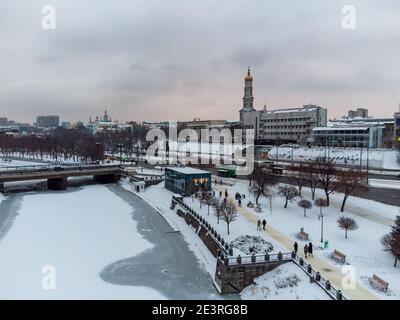 Vista aerea della giornata invernale sull'argine del fiume Lopan e sul campanile di Kharkiv Skver Strilka, Ucraina. Città urbana nevoso nuvoloso giorno Foto Stock