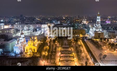 Luci notturne invernali illuminate vista aerea della città. Parco cittadino vicino a Maidan Konstytutsii, Cattedrale di Dormizione , luoghi di interesse di Svyato-Pokrovsʹkyy Monastyr a K. Foto Stock