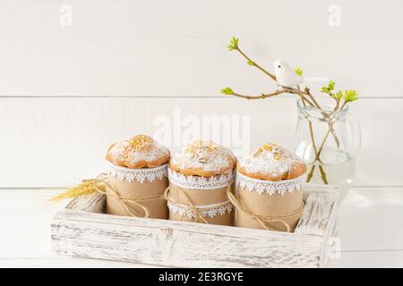 Sistemazione decorazione felice Pasqua vacanza di fondo concetto. Torte di Pasqua in scatola di legno e ramoscelli di primavera. Colori pastello. Foto Stock