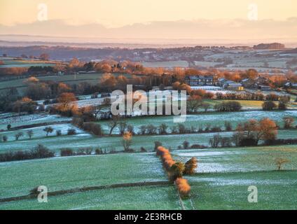 Una leggera polvere di neve copre il paesaggio ad est di Almscliffe Crag nel Lower Wharfedale, mentre la prima luce mette in evidenza il paesaggio amaramente freddo. Foto Stock
