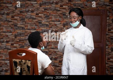 femmina africano medico dà un paziente un pollice in su dopo vaccinazione Foto Stock