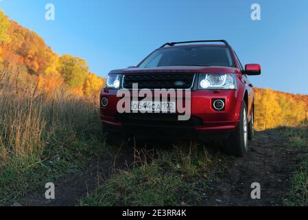 RUSSIA, Rep. DI BASHKORTOSTAN, distretto di Kugarchinsky, villaggio di MRAKOVO - 27 SETTEMBRE 2020. Un SUV rosso LAND ROVER FREELANDER 2 si trova su una strada sterrata Foto Stock