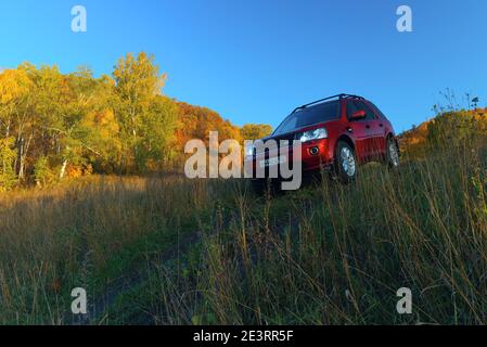 RUSSIA, Rep. DI BASHKORTOSTAN, distretto di Kugarchinsky, villaggio di MRAKOVO - 27 SETTEMBRE 2020. LAND ROVER FREELANDER 2 rosso SUV discesa strada sterrata, autu Foto Stock