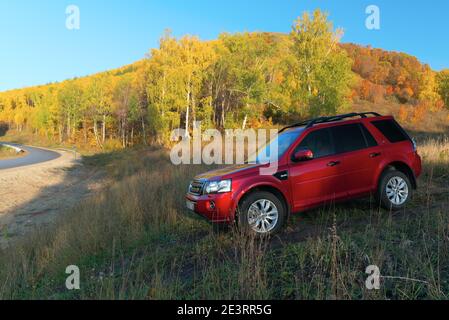 RUSSIA, Rep. DI BASHKORTOSTAN, distretto di Kugarchinsky, villaggio di MRAKOVO - 27 SETTEMBRE 2020. Un SUV rosso LAND ROVER FREELANDER 2 si trova su una strada sterrata, io Foto Stock