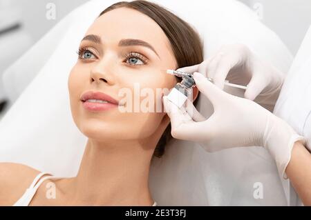 Iniezioni nell'area degli occhi. ringiovanimento del viso, rimozione delle rughe, cosmetologia estetica Foto Stock