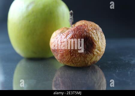 apple brutto guastato e bello buono su uno sfondo nero copyspace. Foto Stock