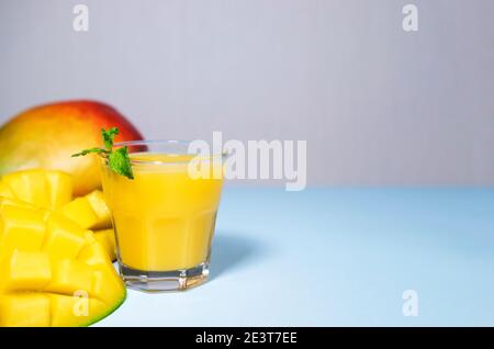 Mango Shake su sfondo blu. Sano bere Vitamina Smoothie. Succo fresco di frutta tropicale di mango. Spazio per testo, CopySpace. Cibo da dieting Foto Stock