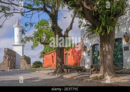 Faro e vecchi pistole portoghesi nel Barrio coloniale Historico / quartiere storico della città Colonia del Sacramento, sud-ovest Uruguay Foto Stock