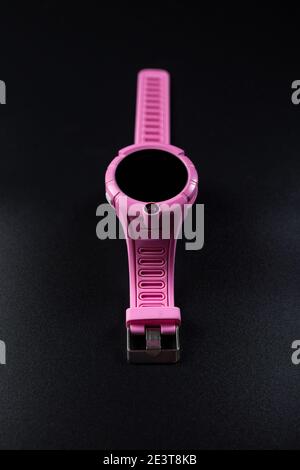 Orologio GPSwatch rosa per bambini, primo piano su sfondo nero. Foto Stock