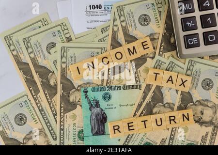 Dichiarazione delle imposte sul reddito modulo delle imposte USA 1040 su sportello del conto del dollaro, con calcolatore controllo della dichiarazione delle imposte economiche Stimulus Foto Stock