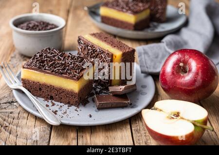 Delizioso dessert al cioccolato con ripieno di mela cremosa, condito con spruzzi croccanti Foto Stock